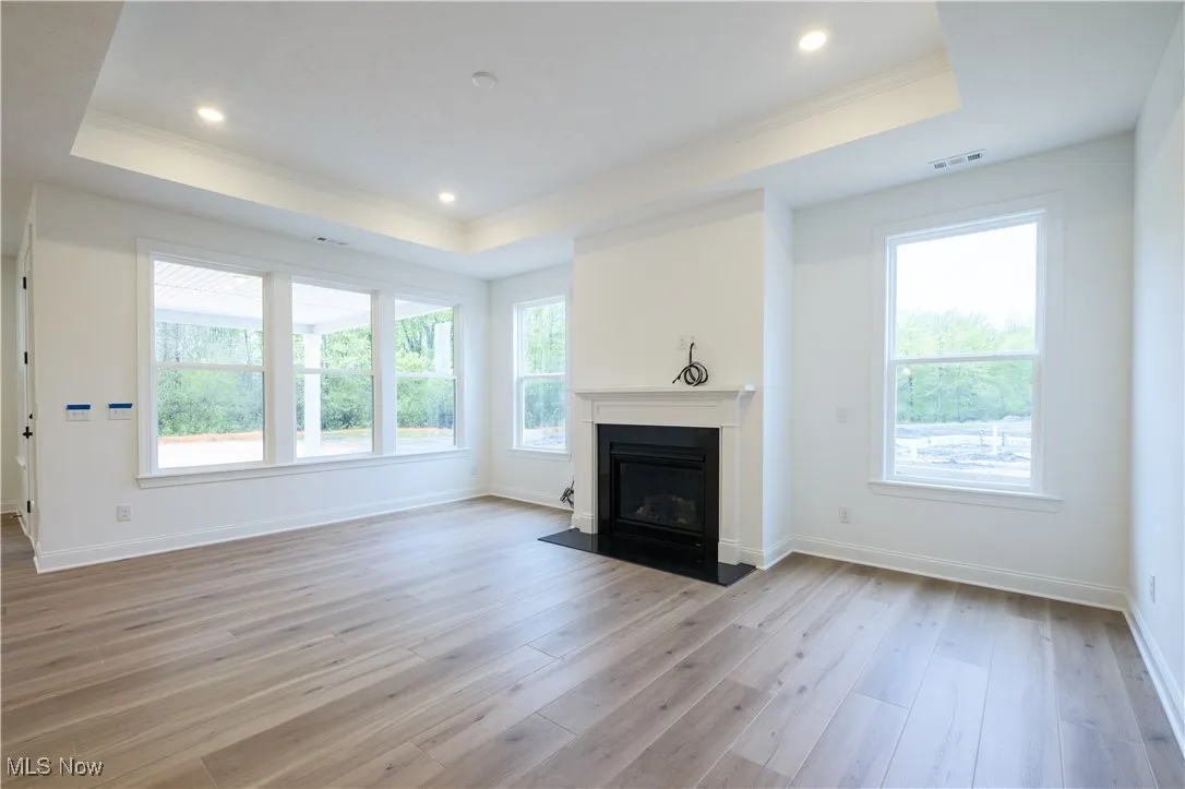 Spacious gathering room with numerous windows and tray ceiling.