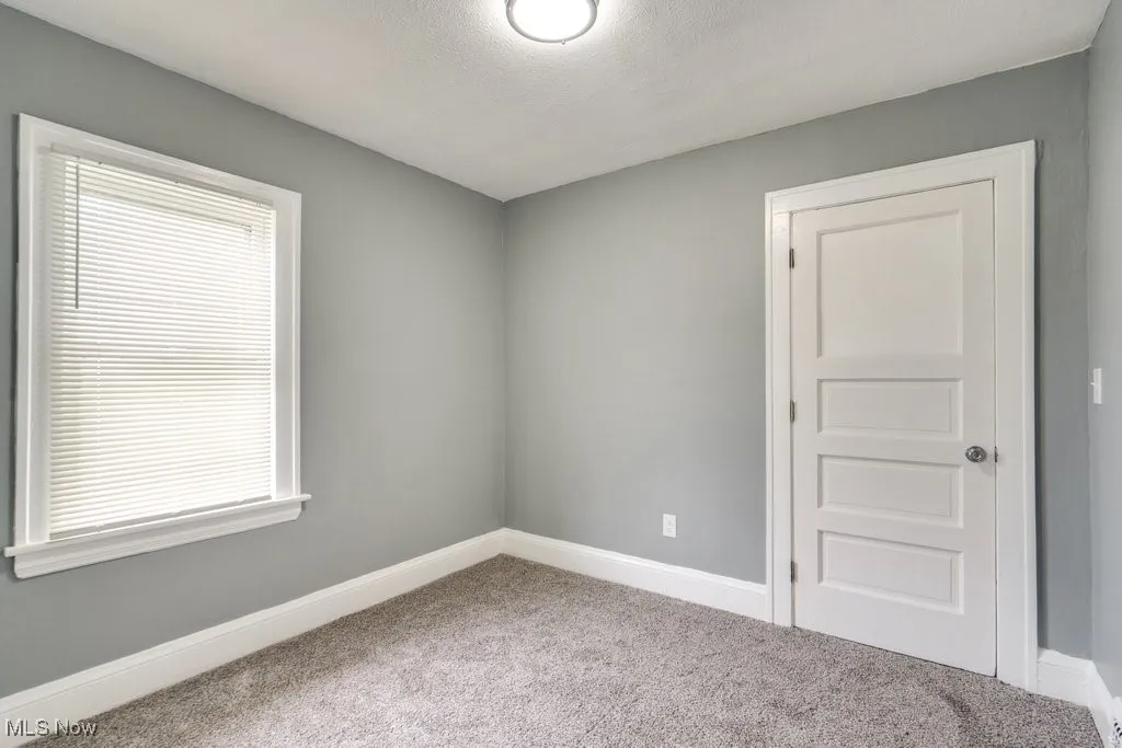 Spare room featuring carpet floors and baseboards
