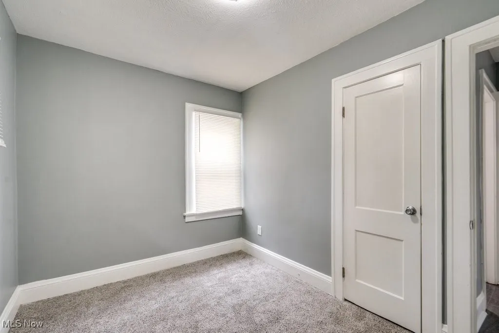 Unfurnished bedroom with carpet and baseboards