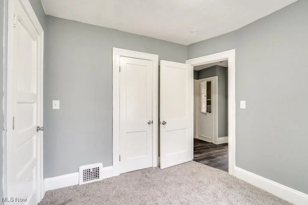 Unfurnished bedroom featuring carpet and a closet