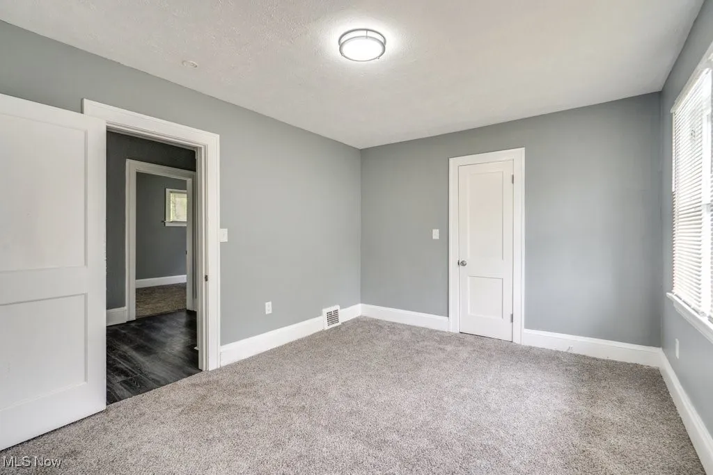 Empty room featuring carpet flooring and a textured ceiling