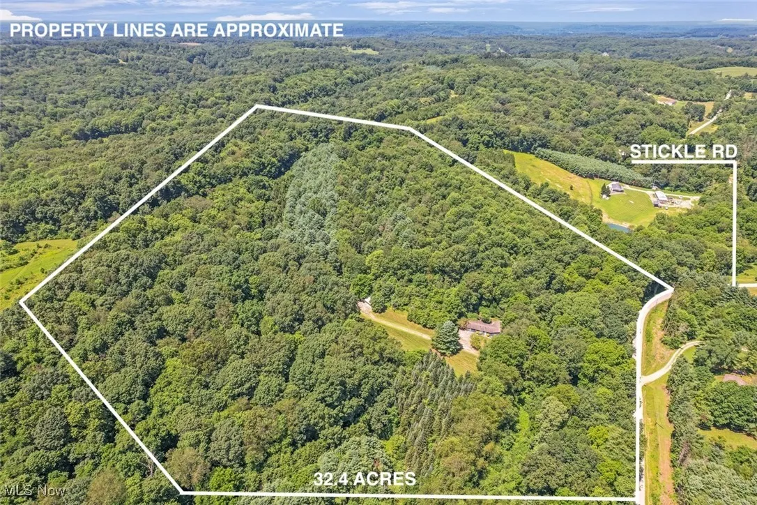 Aerial overview of property's location with a heavily wooded area and property boundaries highlighted