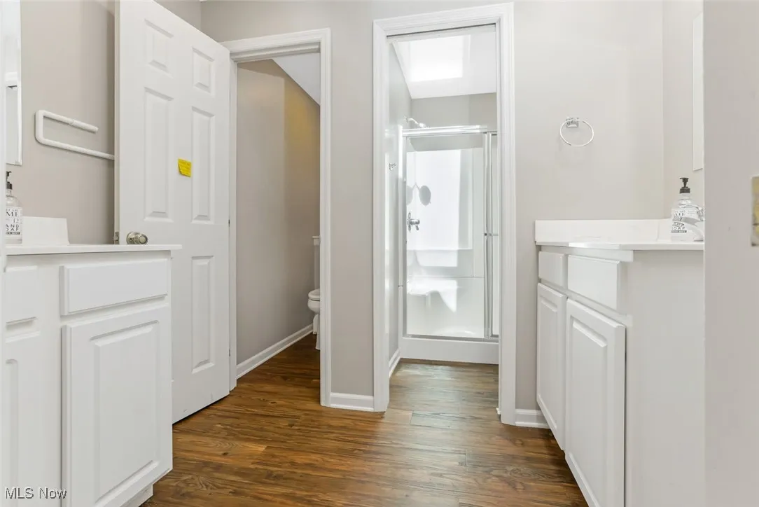 Bathroom with vanity, a shower stall, and wood finished floors