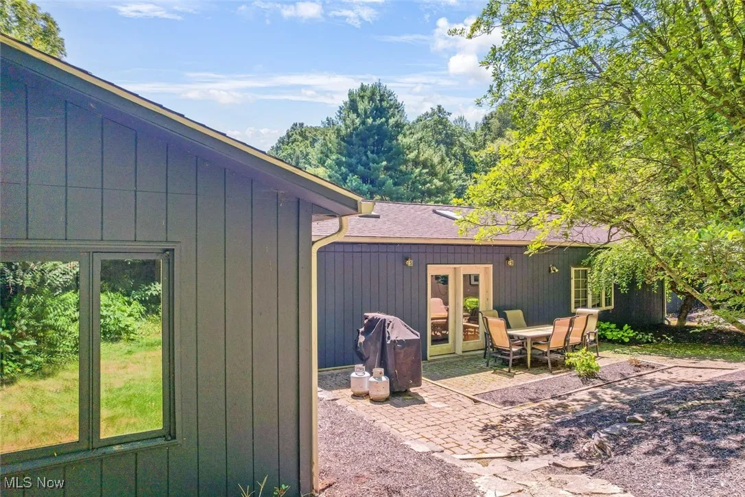 Back of property with french doors, a patio area, and a shingled roof