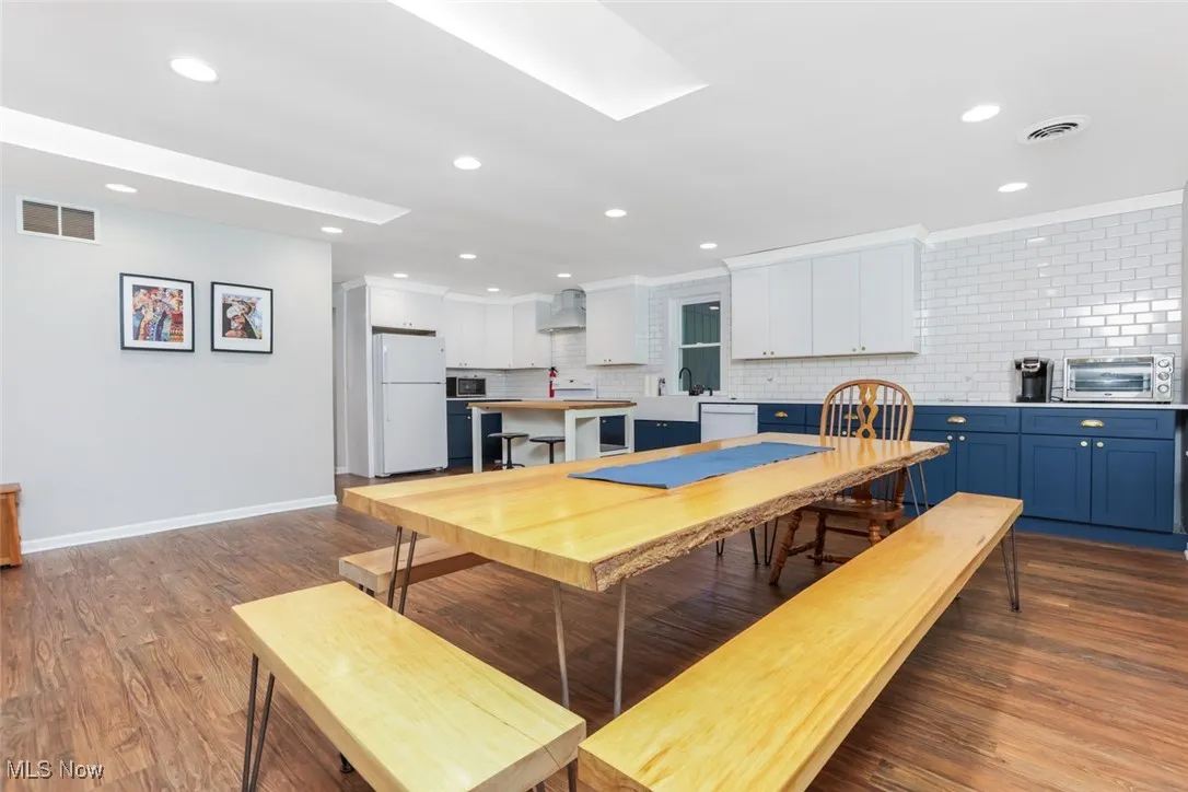 Dining room with recessed lighting, wood finished floors, and ornamental molding