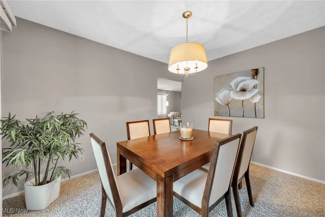 Dining area with carpet flooring and a chandelier