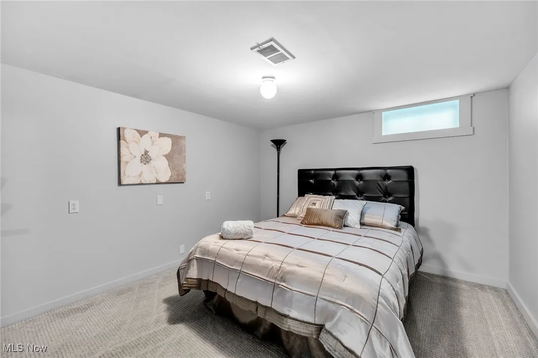 Bedroom featuring carpet and baseboards