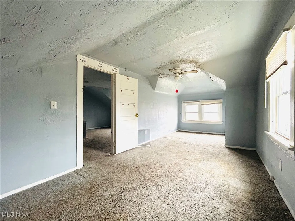 Unfurnished room featuring a textured ceiling, baseboards, and carpet floors