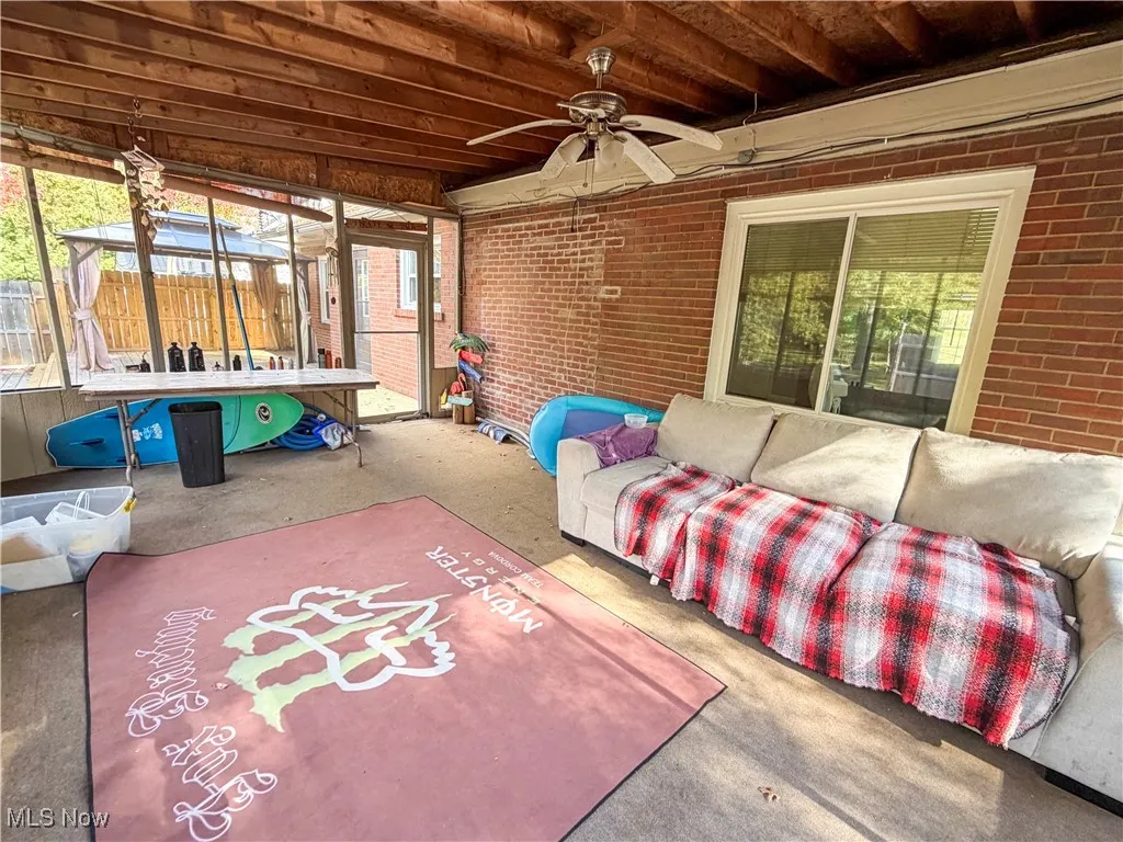 Sunroom / solarium featuring an outdoor living space, a ceiling fan, and a patio area