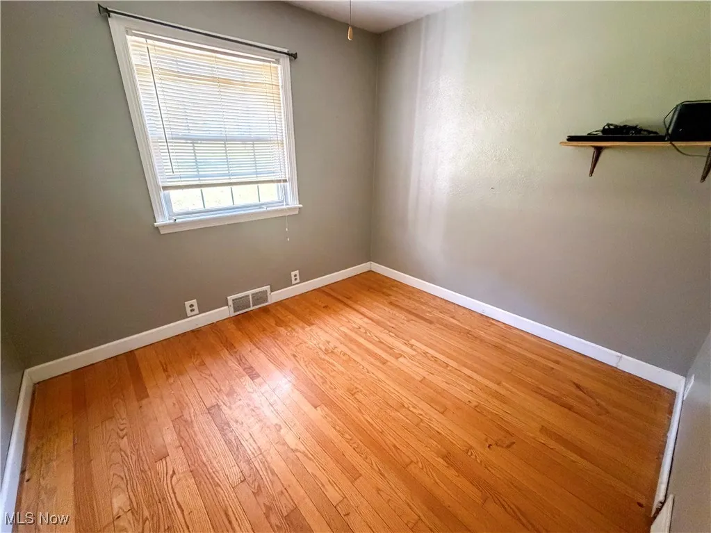 Spare room with baseboards and light wood-style floors