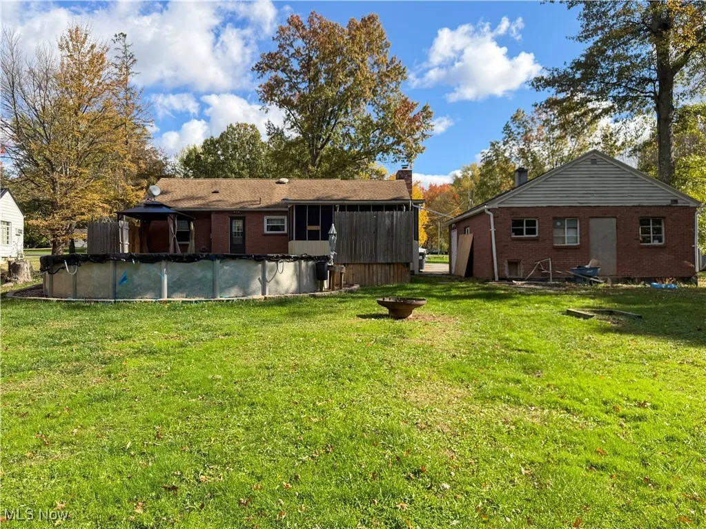 View of grassy yard with a covered pool