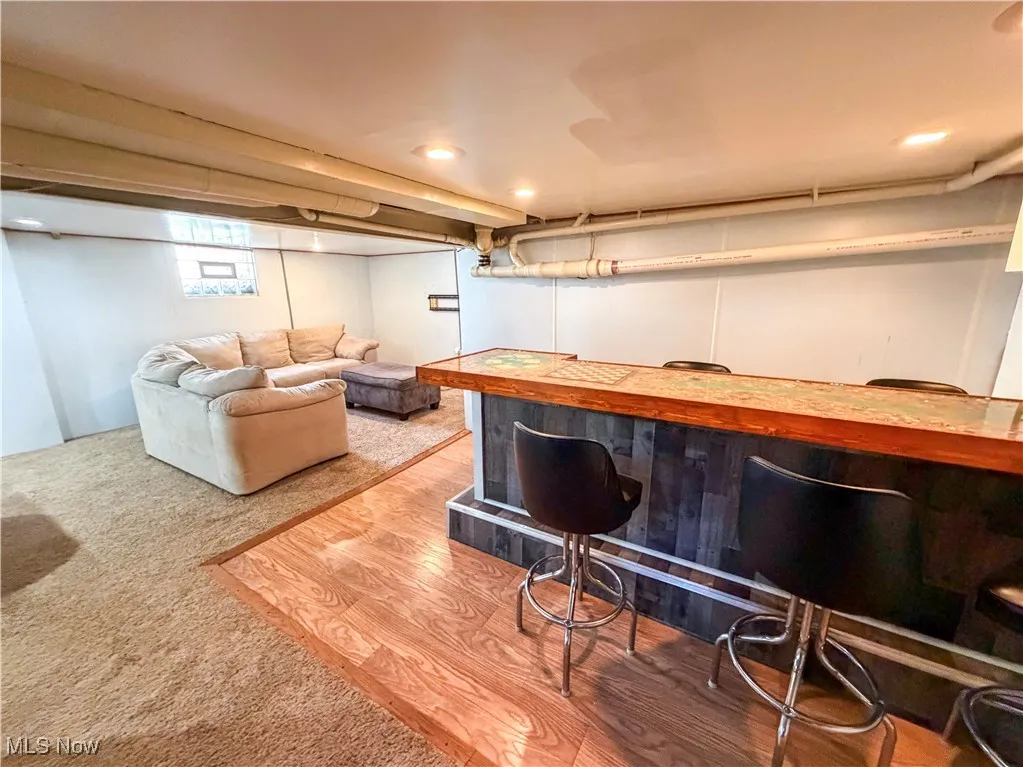Indoor dry bar with light colored carpet and light wood-style floors
