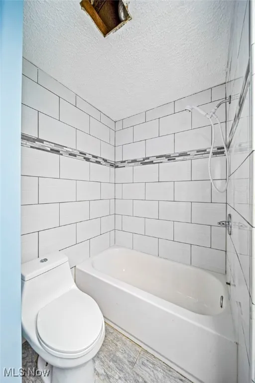 Bathroom with a textured ceiling and  shower combination