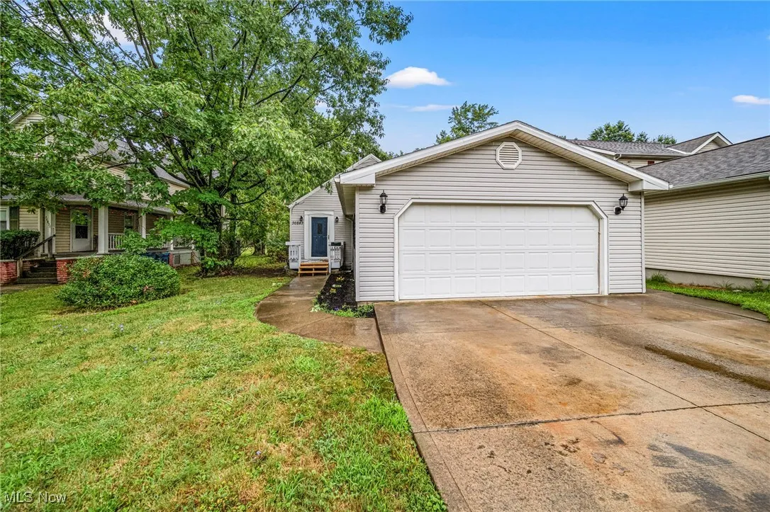 View of front of property featuring concrete driveway and a front lawn