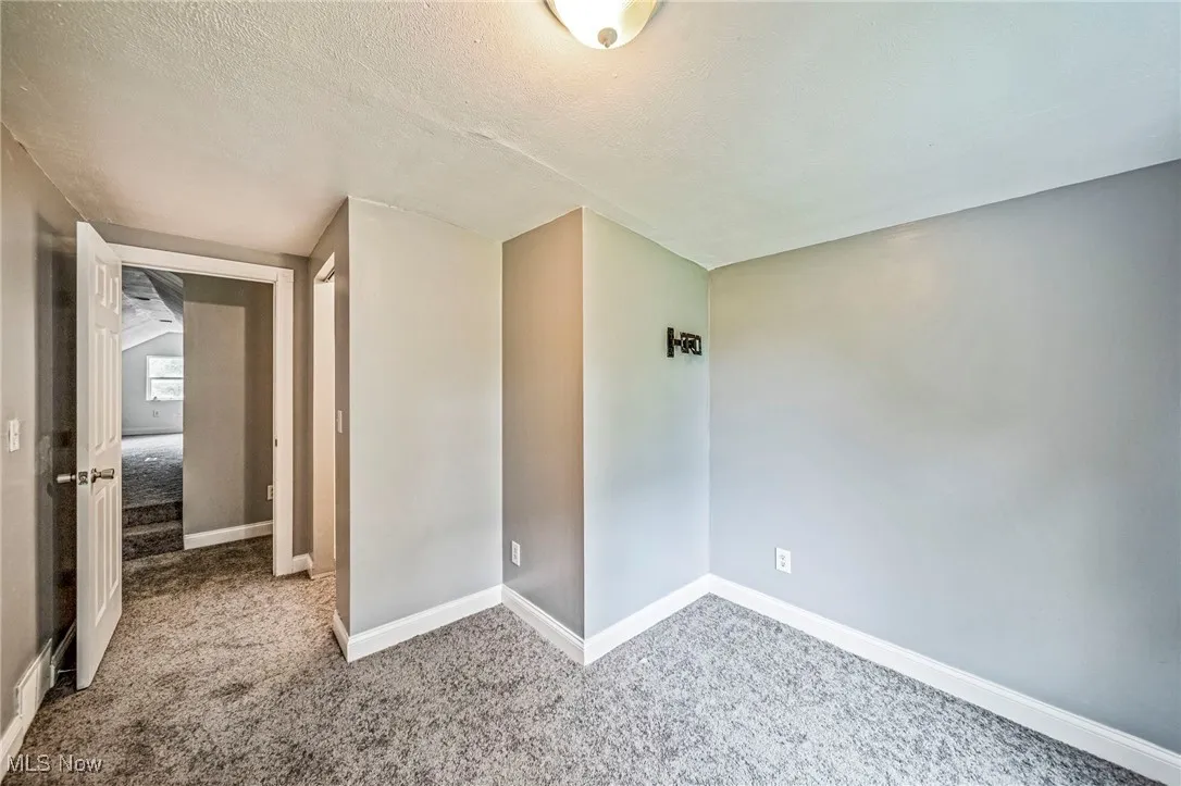 Unfurnished room featuring carpet flooring and a textured ceiling