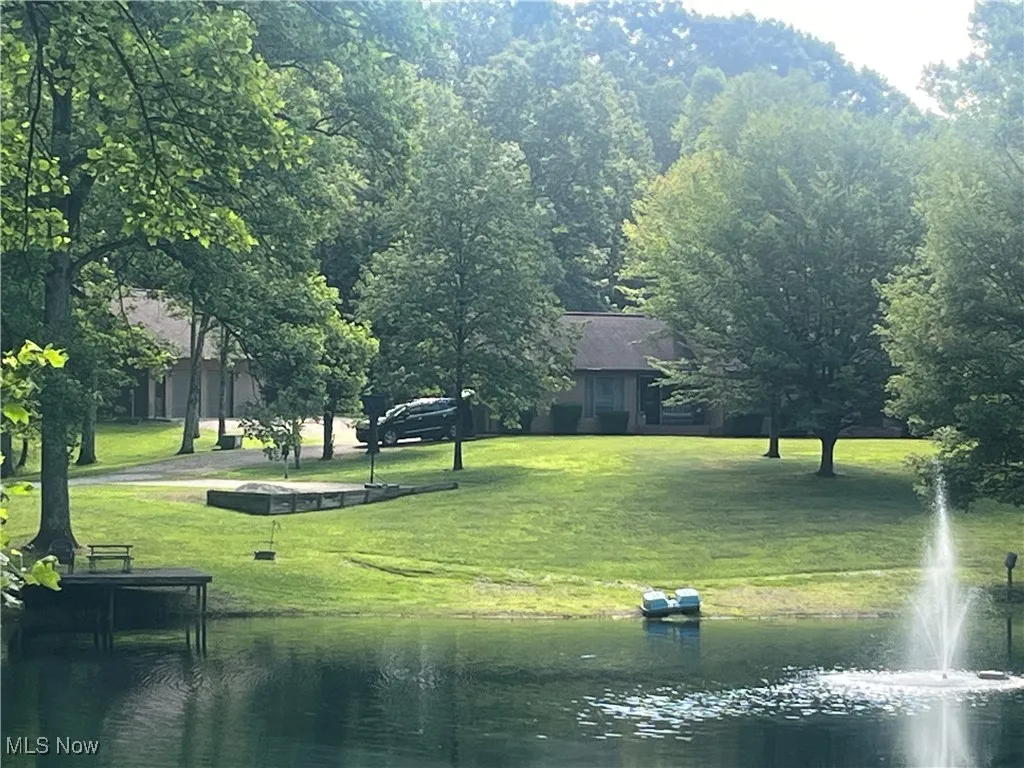 View of community featuring a water view and a lawn