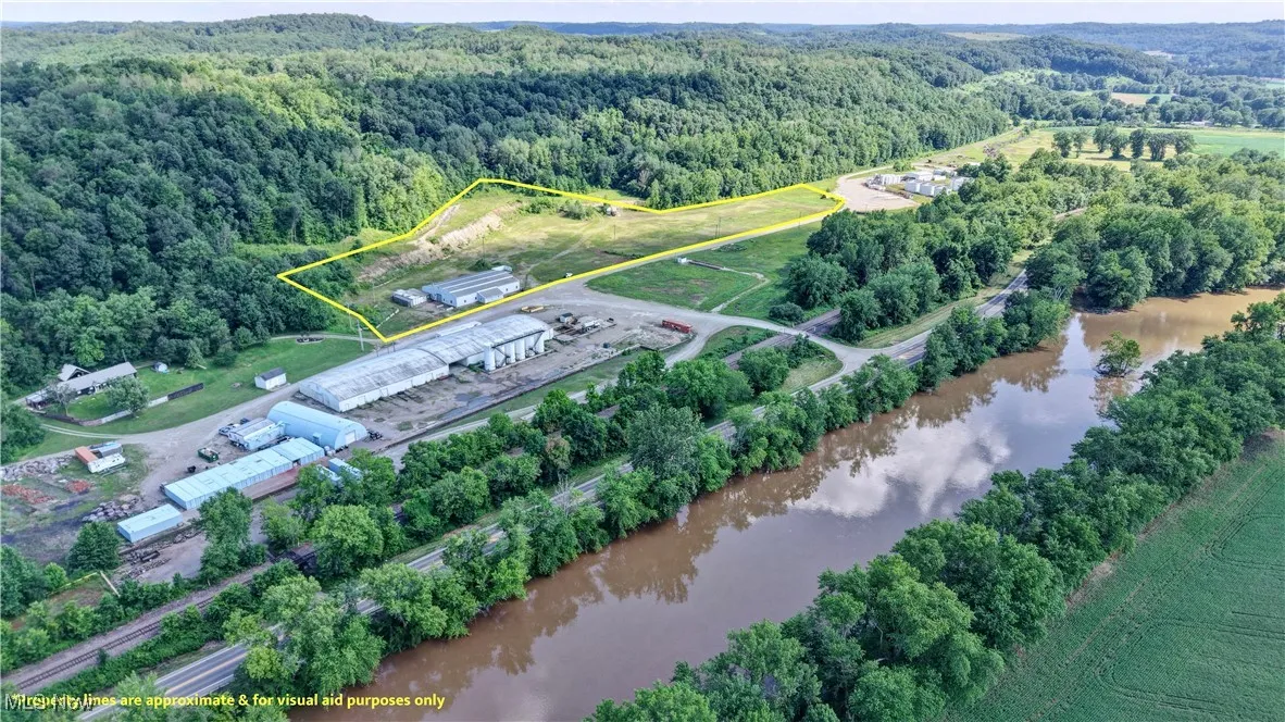 Aerial view of property and surrounding area featuring a large body of water and property boundaries highlighted