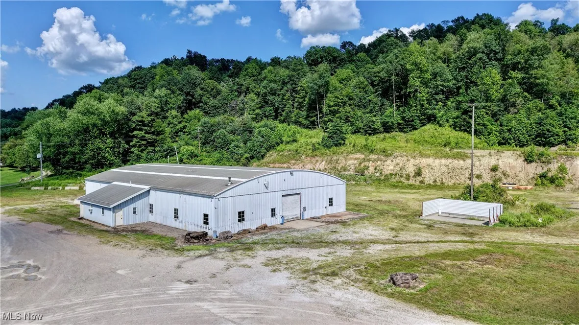 Aerial view of property and surrounding area with a heavily wooded area