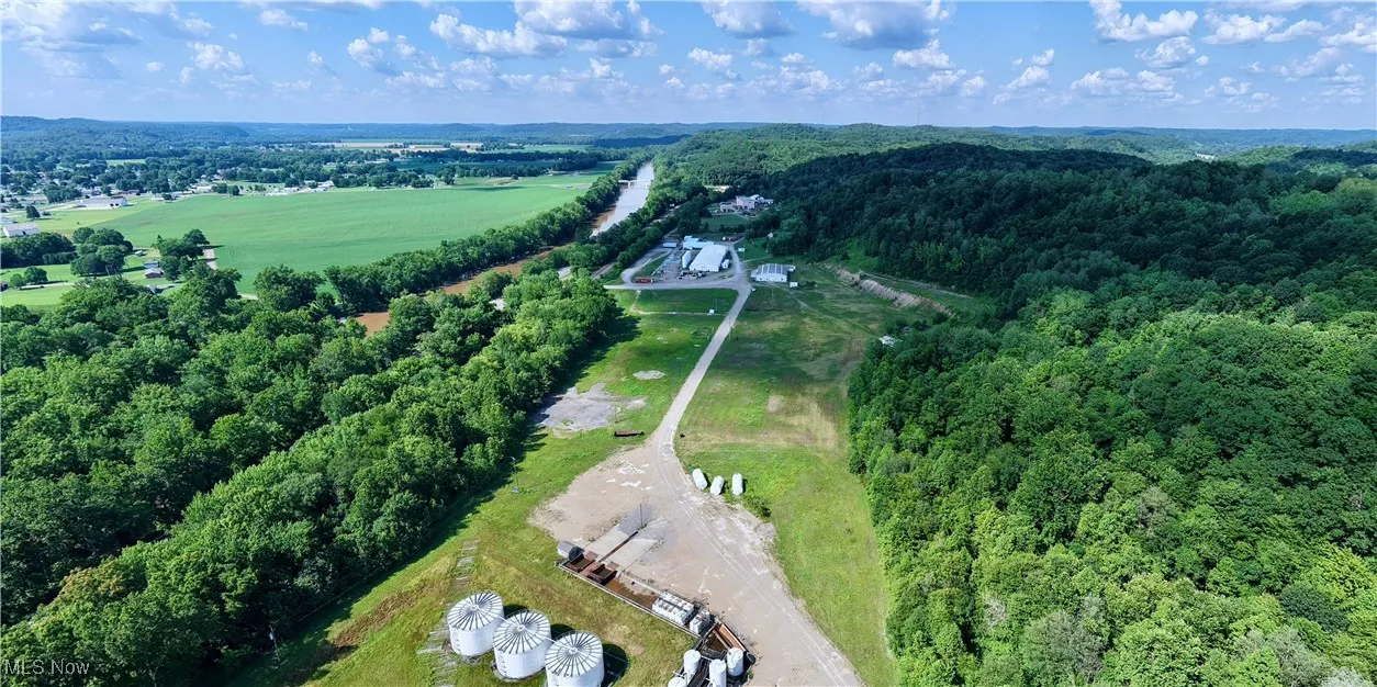 Aerial view of property and surrounding area featuring a forest