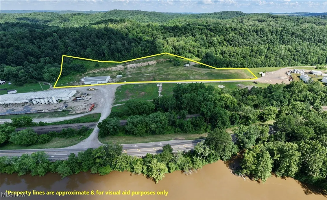Aerial overview of property's location with a heavily wooded area and property parcel outlined