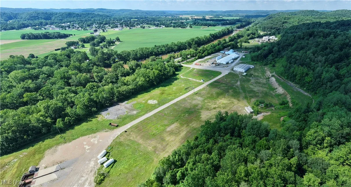 Aerial view of property's location with a heavily wooded area