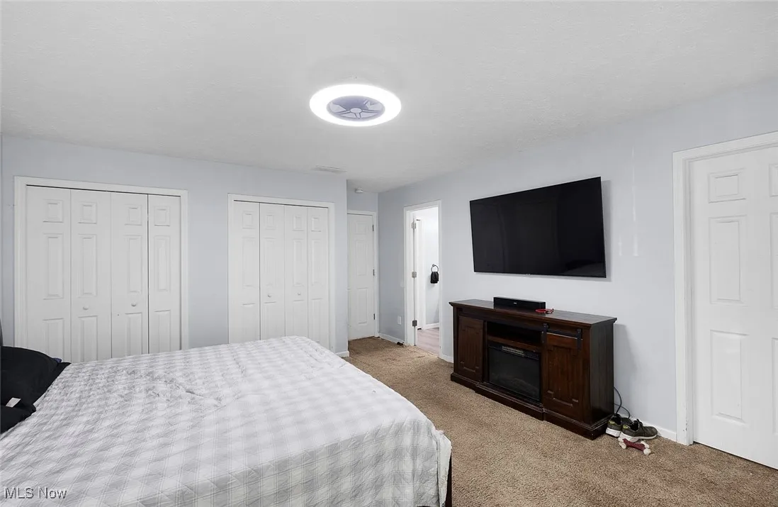 Carpeted bedroom with two closets and en suite