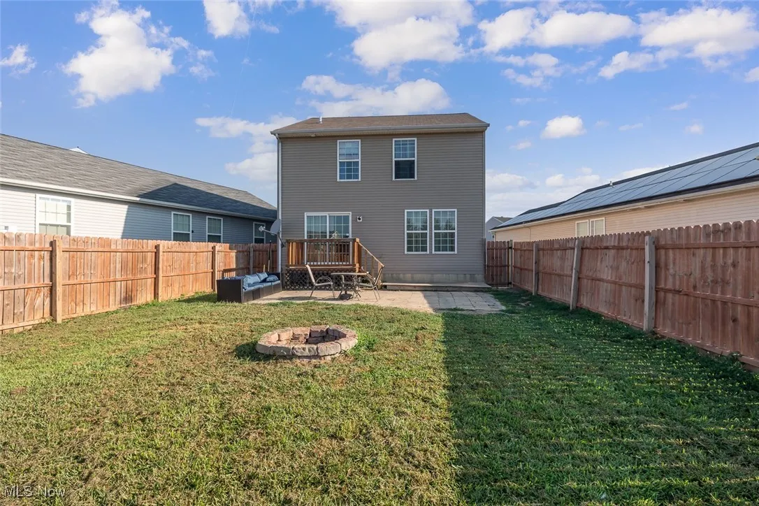 Back of house featuring a fire pit, a patio area, and a fenced backyard