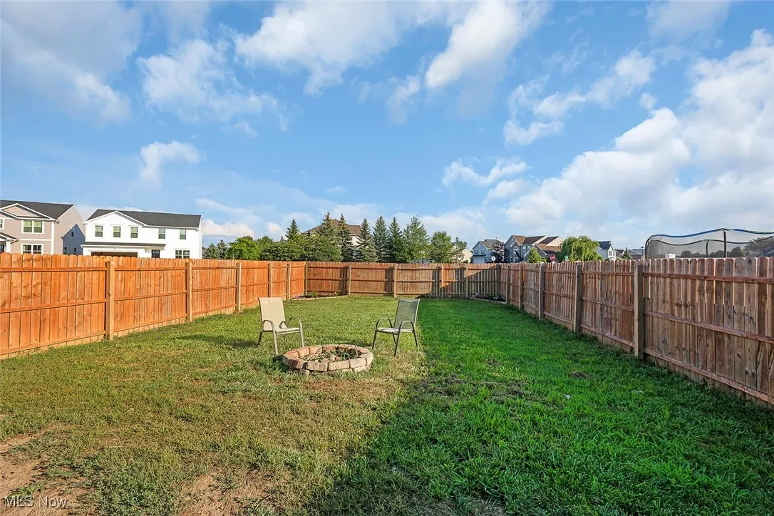 Fenced backyard with an outdoor fire pit
