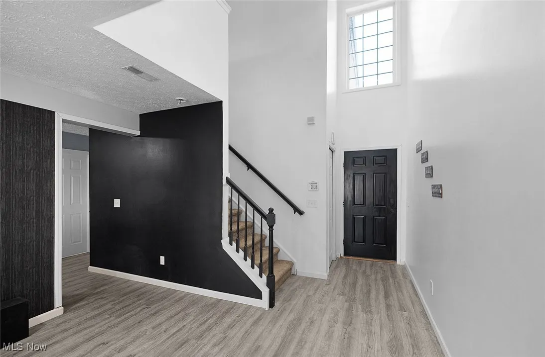 Foyer entrance featuring wood finished floors and stairway