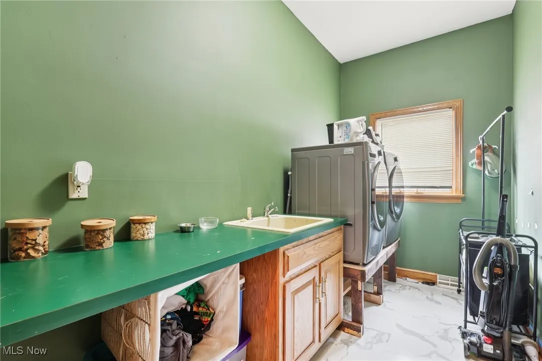 Laundry room with washer and dryer and light marble finish floors