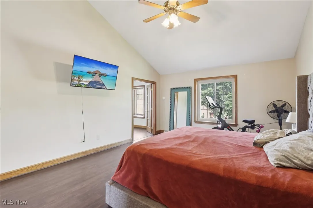 Bedroom featuring high vaulted ceiling, wood finished floors, and ceiling fan