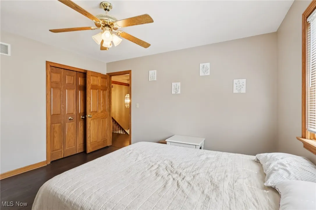 Bedroom with dark wood finished floors, a ceiling fan, and a closet