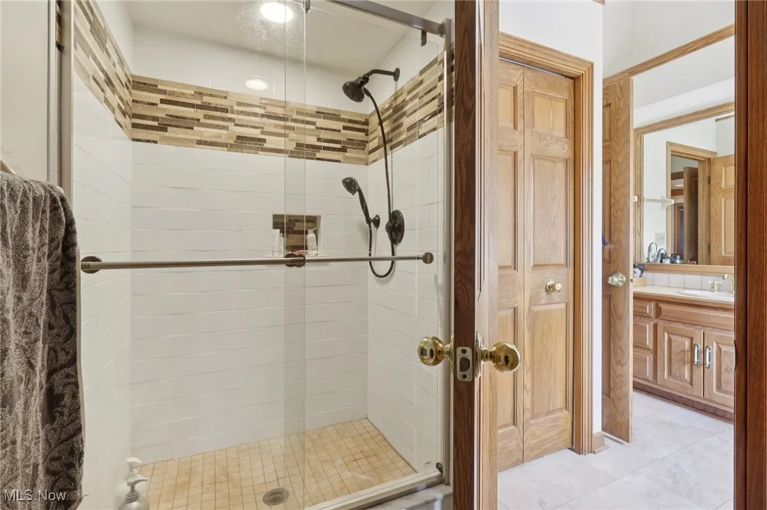 Bathroom featuring a shower stall and vanity