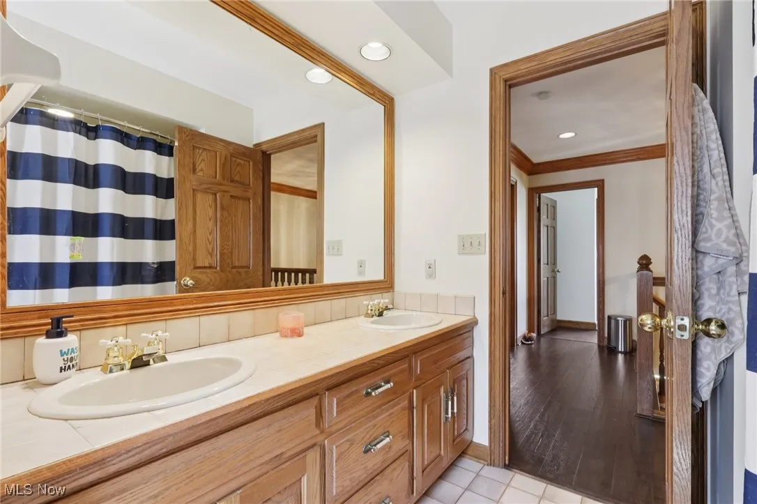 Bathroom with double vanity, recessed lighting, crown molding, and tile patterned floors