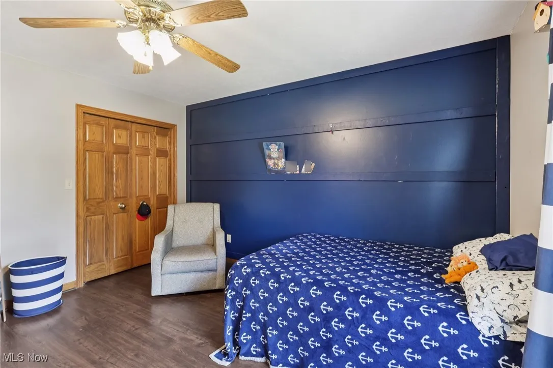 Bedroom with wood finished floors, a closet, and ceiling fan