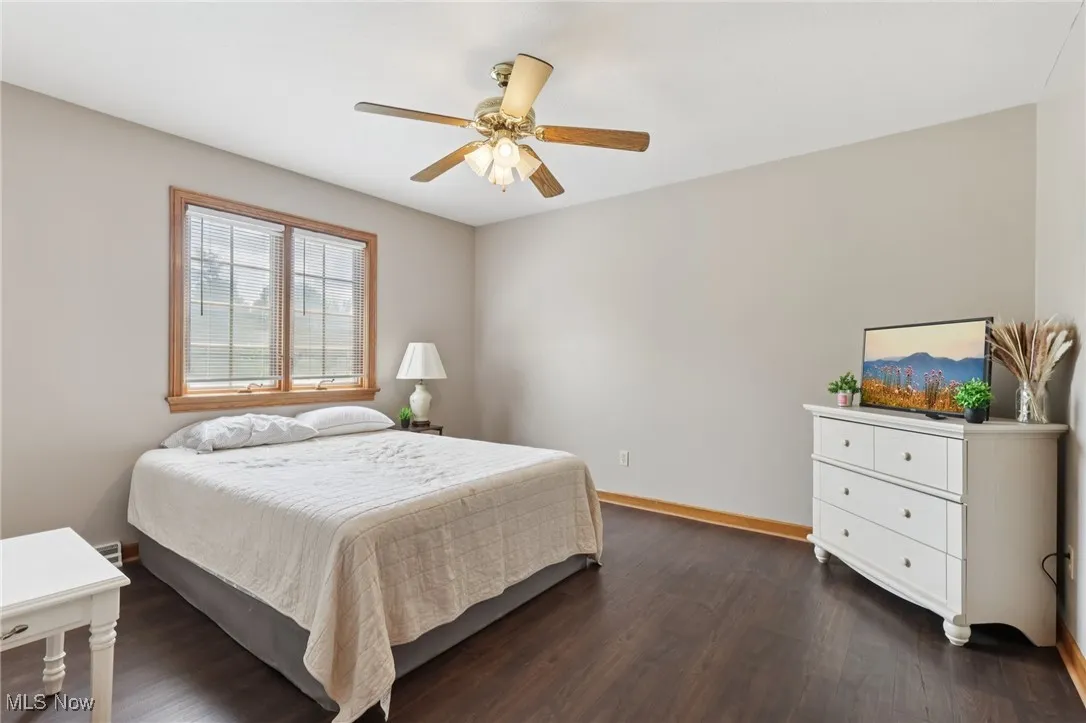 Bedroom with dark wood finished floors and ceiling fan