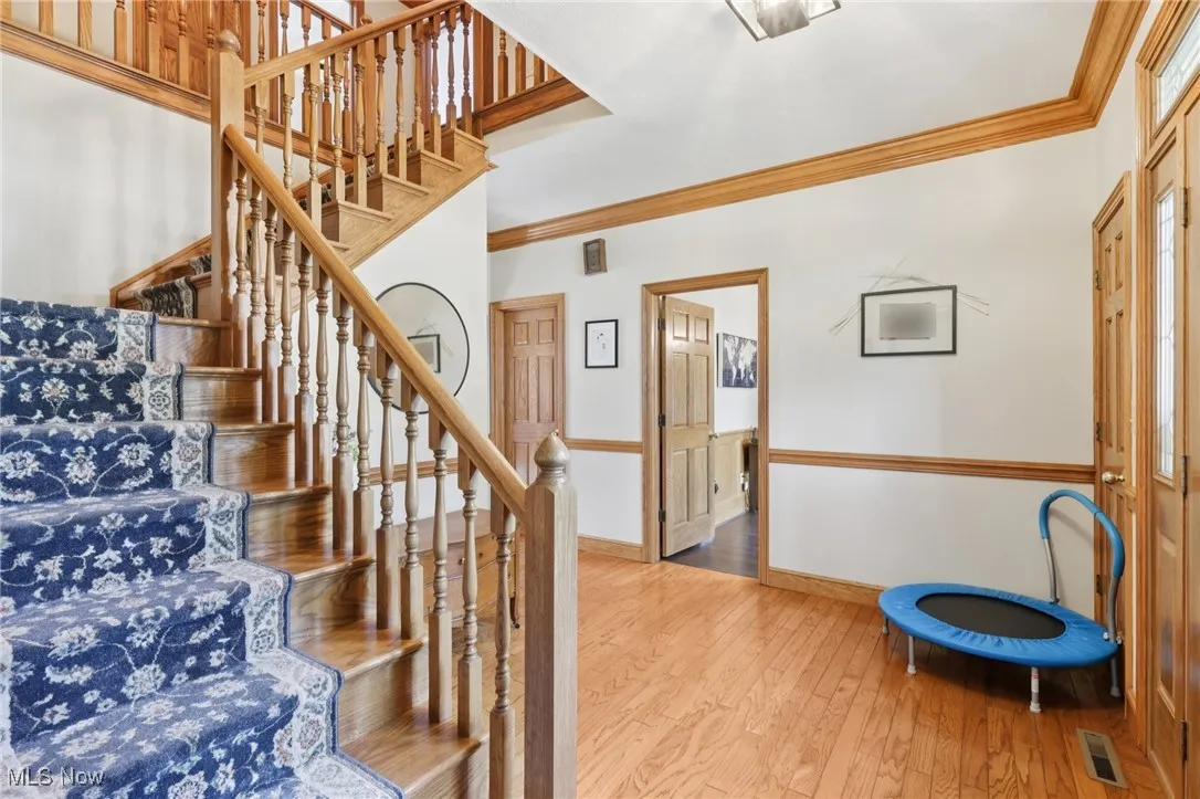 Stairs featuring crown molding and wood-type flooring