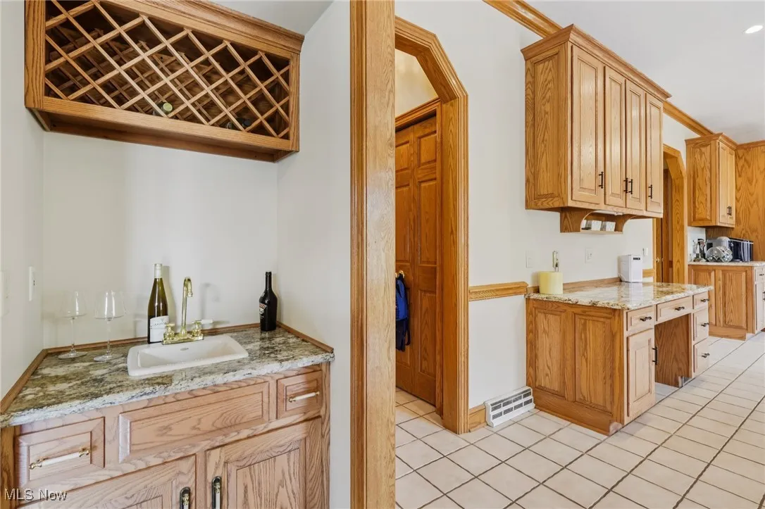 Kitchen featuring light tile patterned flooring and light stone countertops
