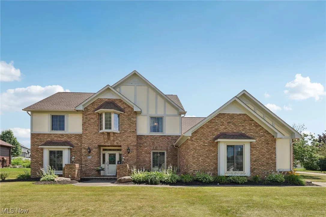 View of front of home featuring a front lawn and brick siding