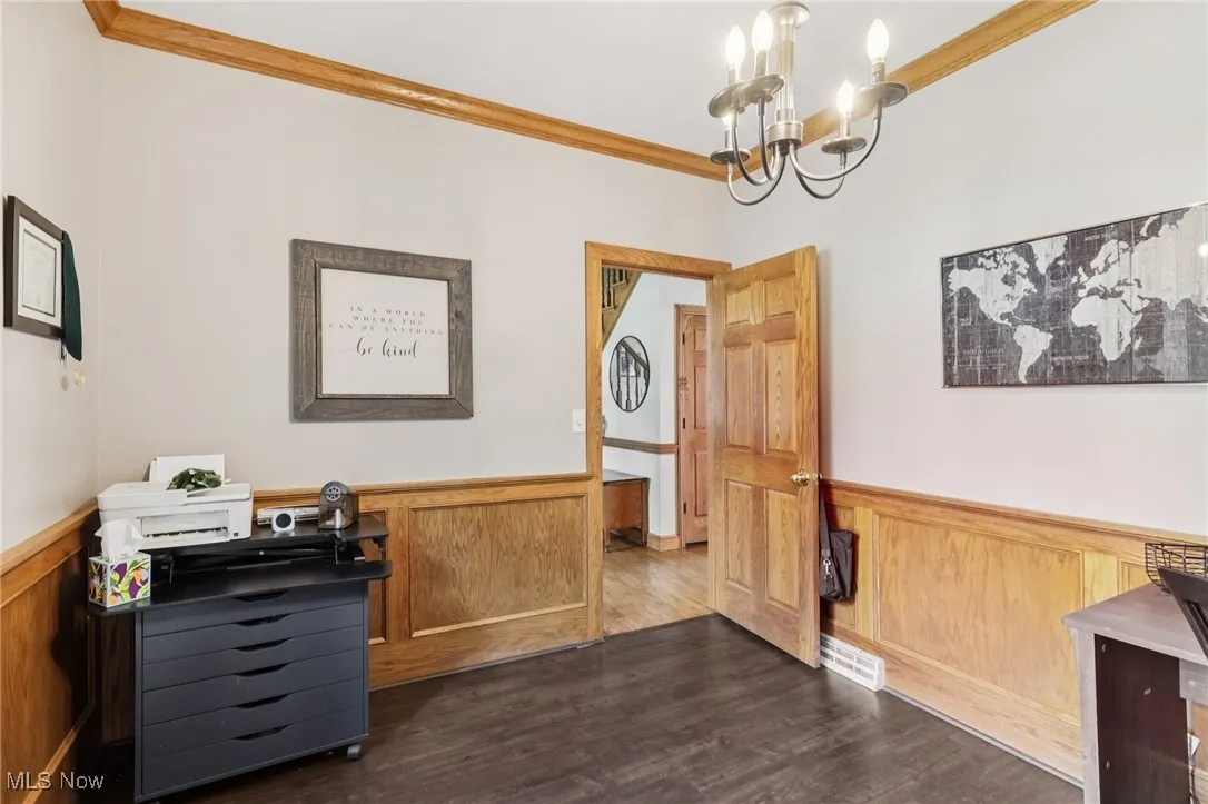 Home office with wainscoting, ornamental molding, a chandelier, and dark wood finished floors