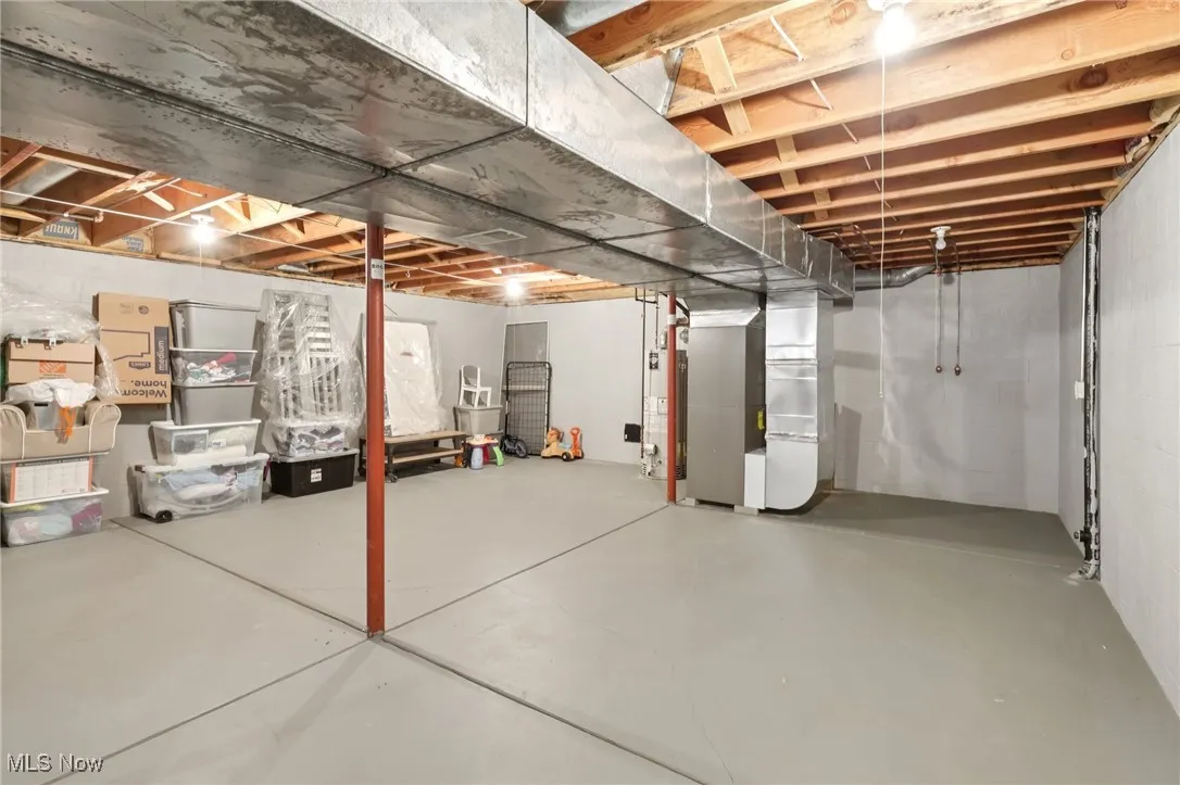 Unfinished basement featuring heating unit and water heater