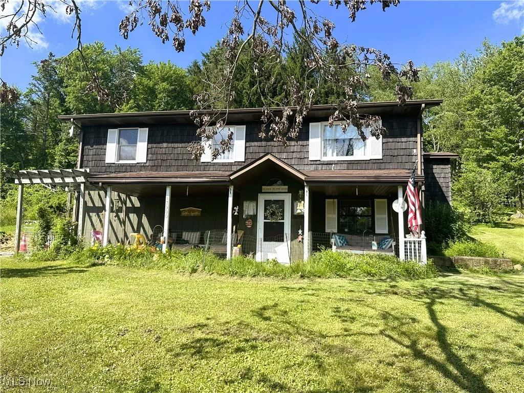 View of front of home with a front lawn, a porch, and a pergola