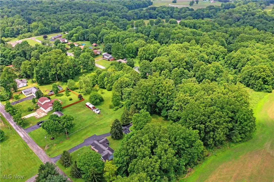 Aerial view of property and surrounding area featuring a heavily wooded area