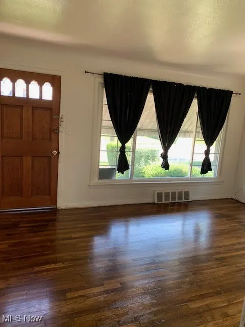 Entrance foyer featuring dark wood-style floors and baseboards