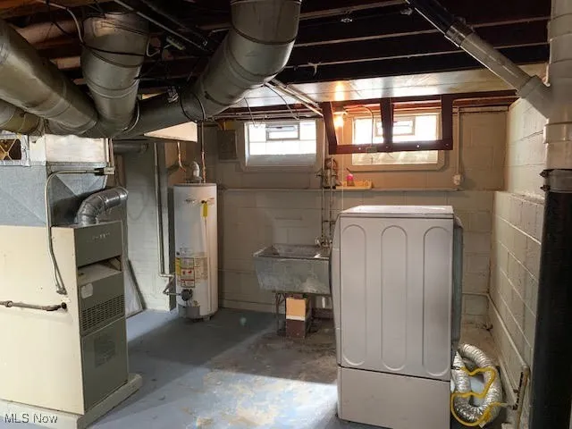 Below grade area with gas water heater, washer / dryer, and heating unit