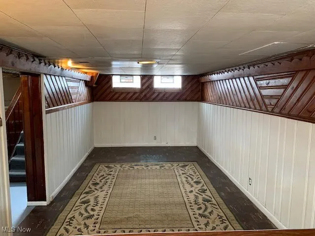 Below grade area featuring wooden walls and stairs