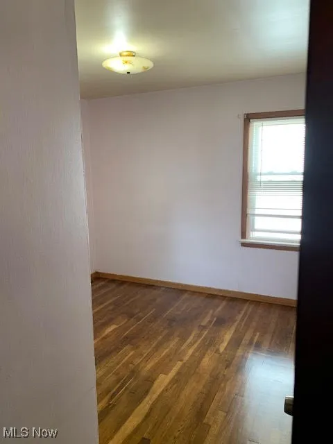 Spare room featuring wood finished floors and baseboards
