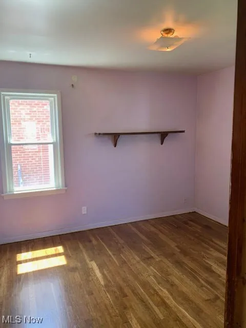 Spare room featuring wood finished floors and baseboards