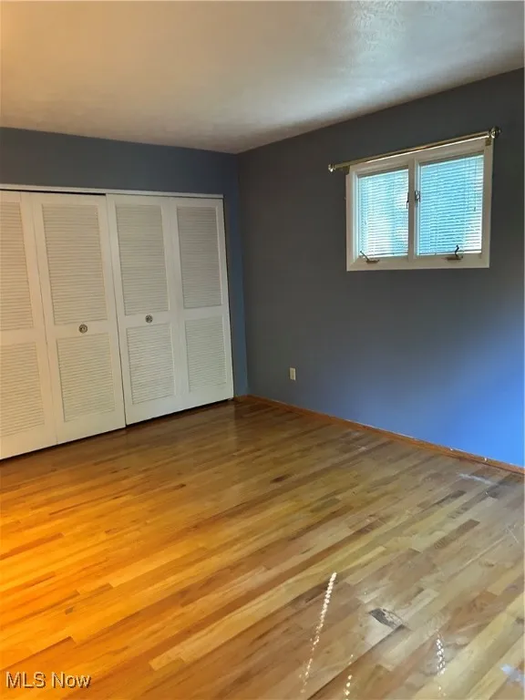 Unfurnished bedroom with light wood-style flooring and a closet