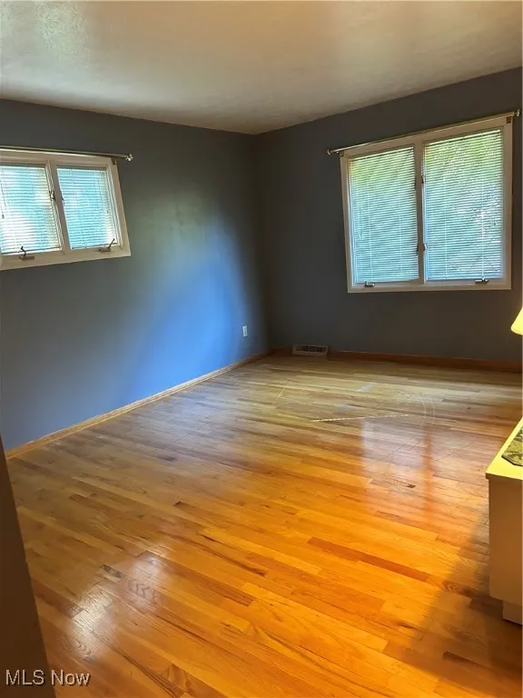 Spare room featuring light wood finished floors and baseboards